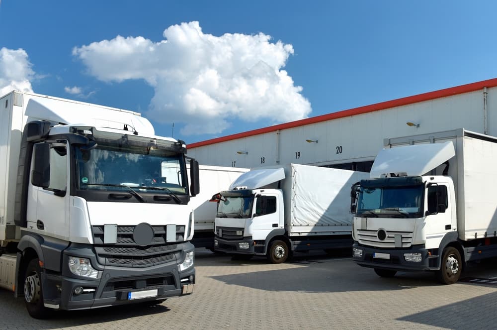 Trucks loading at a forwarding agency’s depot, highlighting the transport and logistics operations involved in the goods trade industry.