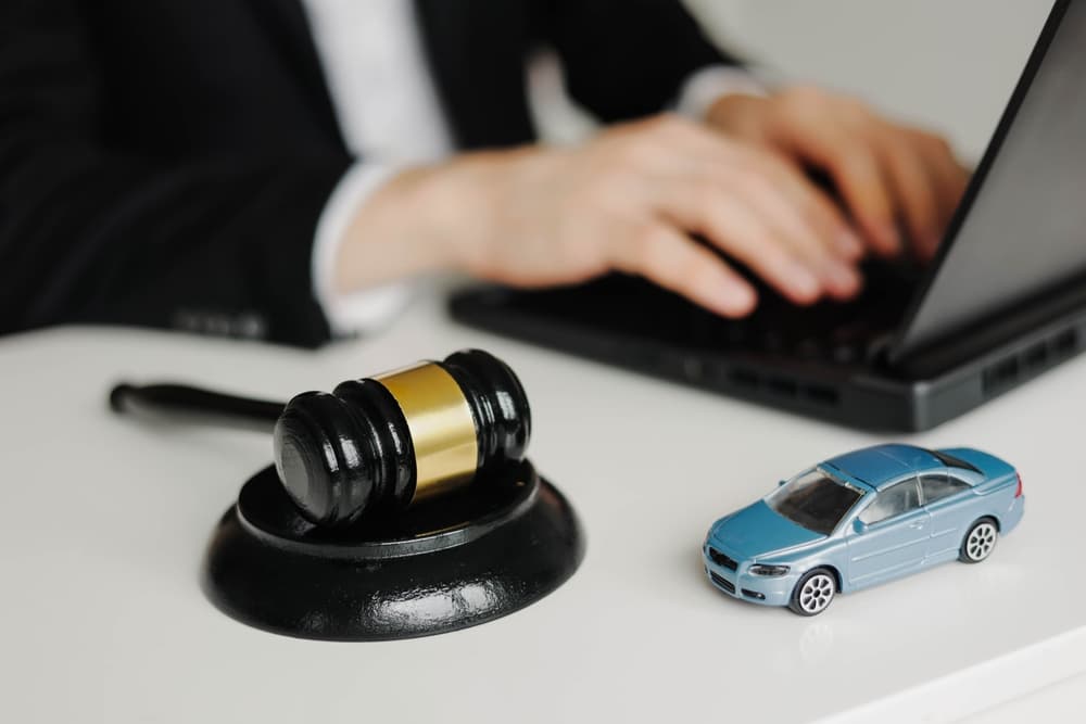 Car Accident Liability: Insurance Lawyer, Gavel, and Legal Work on Laptop.