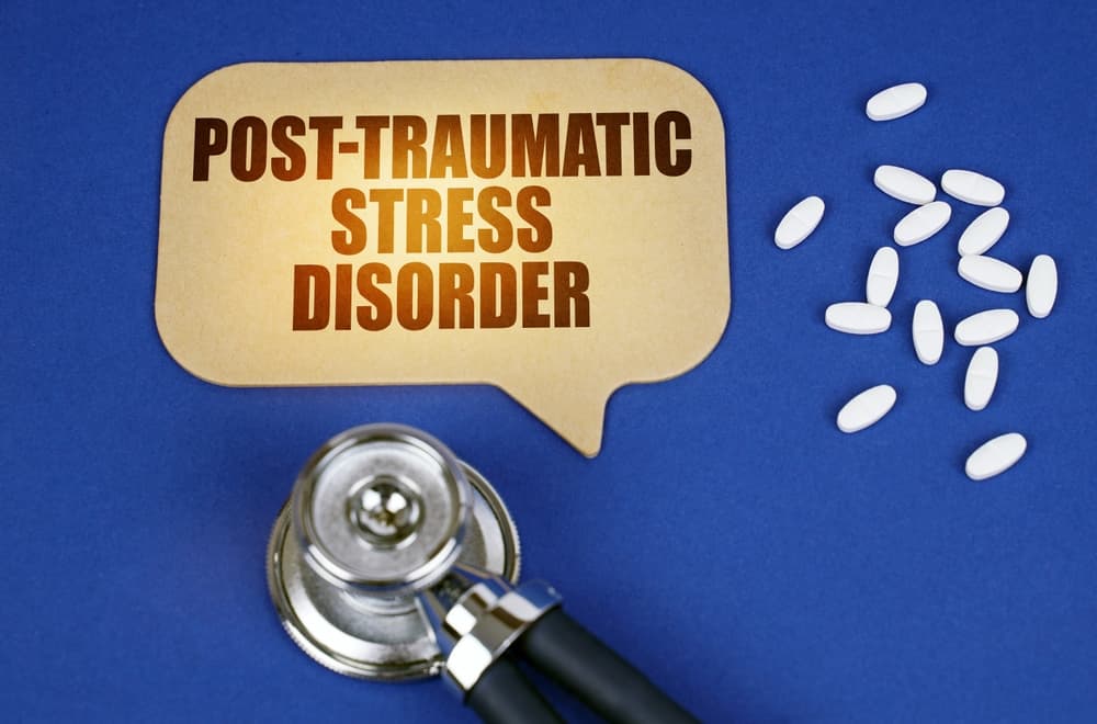 An image representing the concept of a stethoscope and a sign reading "Post-Traumatic Stress Disorder" on a blue tablet surface, conveying the medical theme effectively.